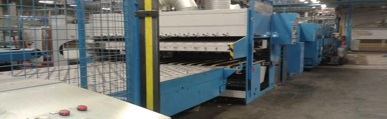 Línea de cartón ondulado de gran formato con estructura azul en planta de producción