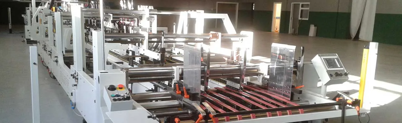 Línea plegadora-encoladora completa instalada en nave industrial