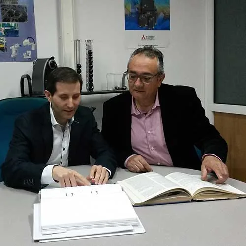 Dos técnicos de Autymat revisando la documentación técnica de un proyecto de automatización